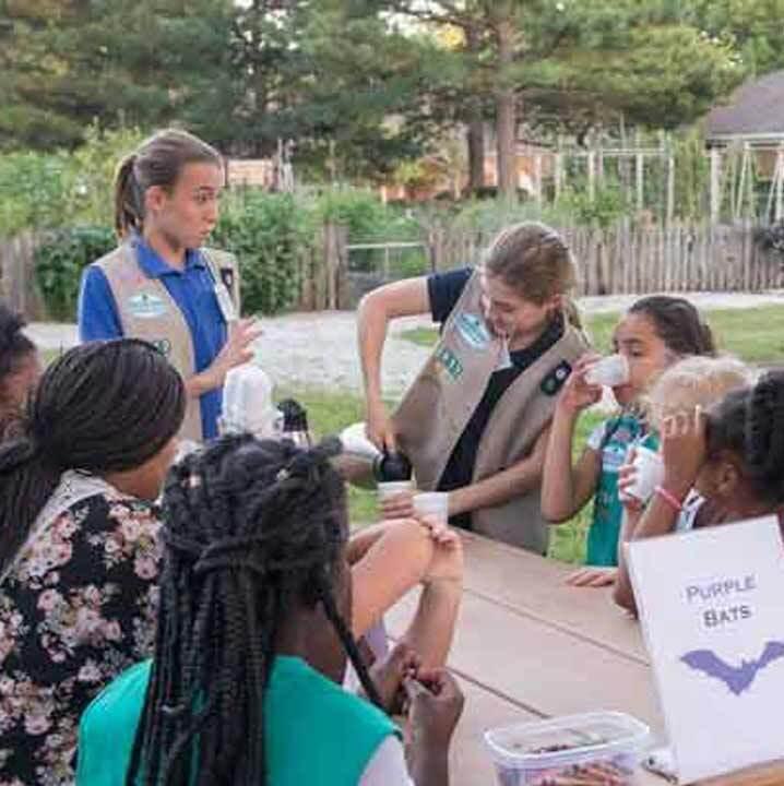 Troop leader teaching girls scouts about bats.