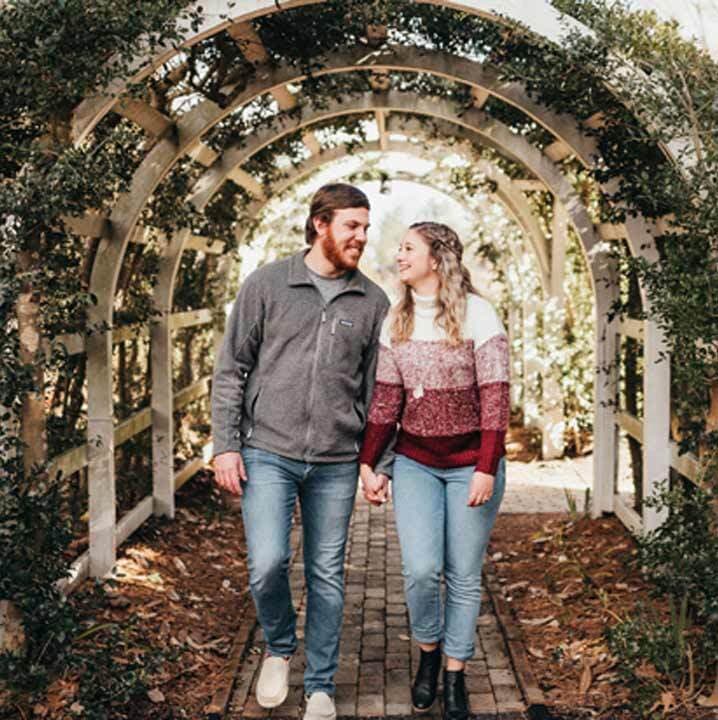 Couple Waking Through Flowered Archway