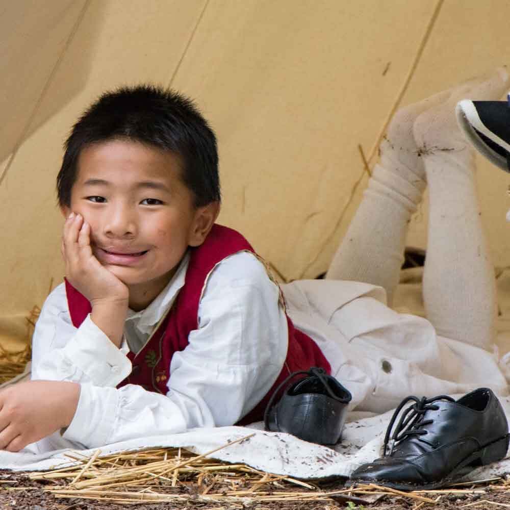 Boy in Costume Laying on Straw Floor