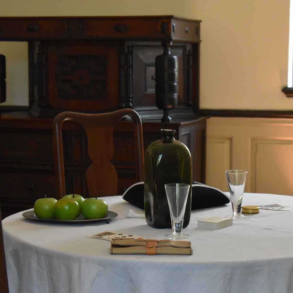 Dinner Table with Apples, Glasses, and a Bottle of Water