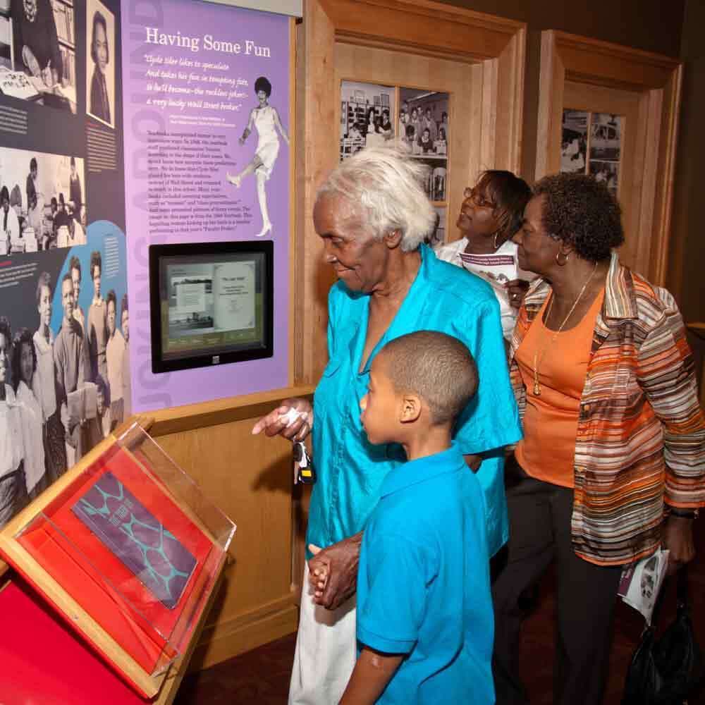 Grandma with Grandson Looking at Photos of Student on a Display