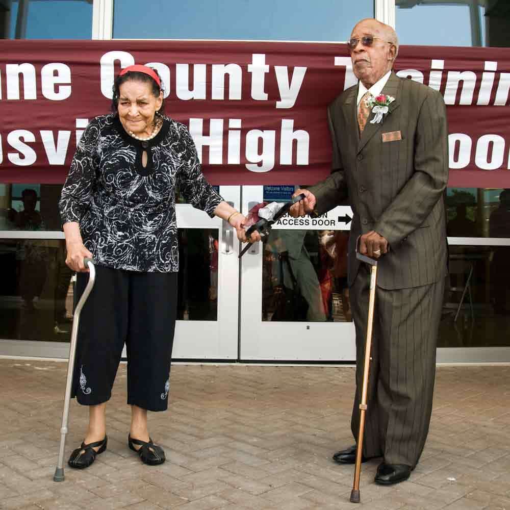 Two Elderly People Cutting Ribbon on Opening Day