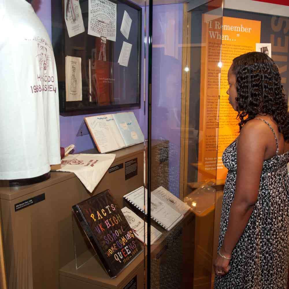 Visitors Looking at Display Case of Uniform Certficates